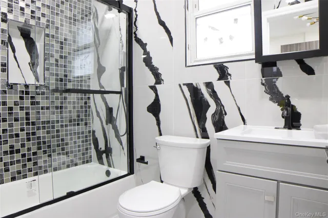 a white toilet sitting next to a bathroom sink