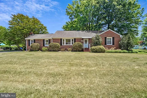 a front view of a house with a yard and tree