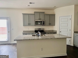 11899 Conrad Circle Hampton, GA 30228 - Photo 4 of 30 a kitchen with granite countertop a refrigerator and a stove top oven