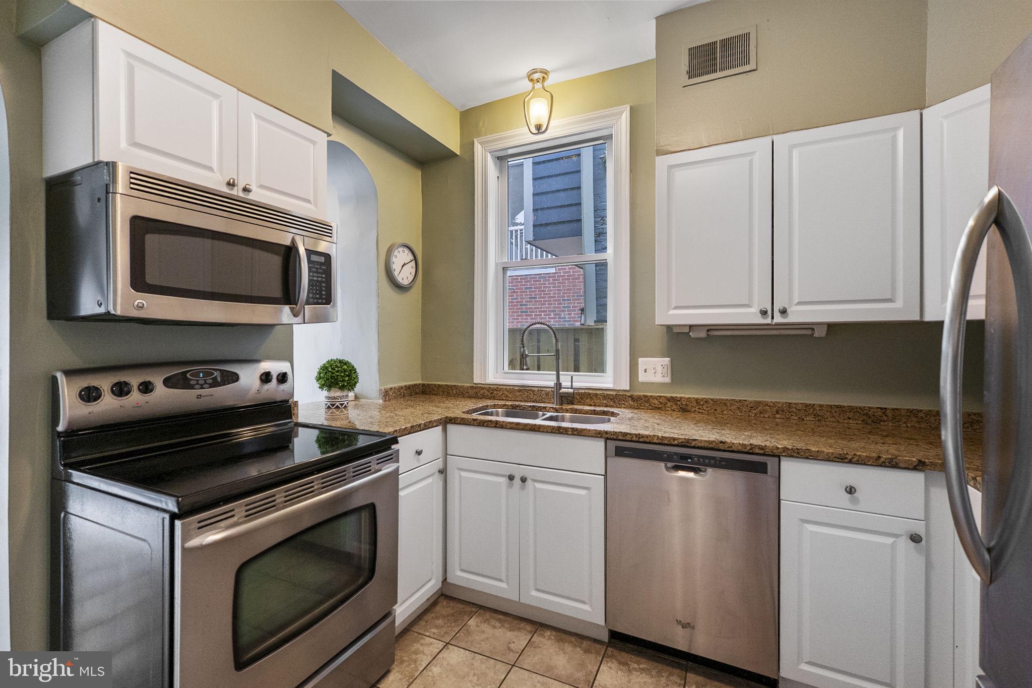 145 D Street Southeast Washington, DC 20003 - Photo 16 of 44 a kitchen with granite countertop cabinets stainless steel appliances and a sink