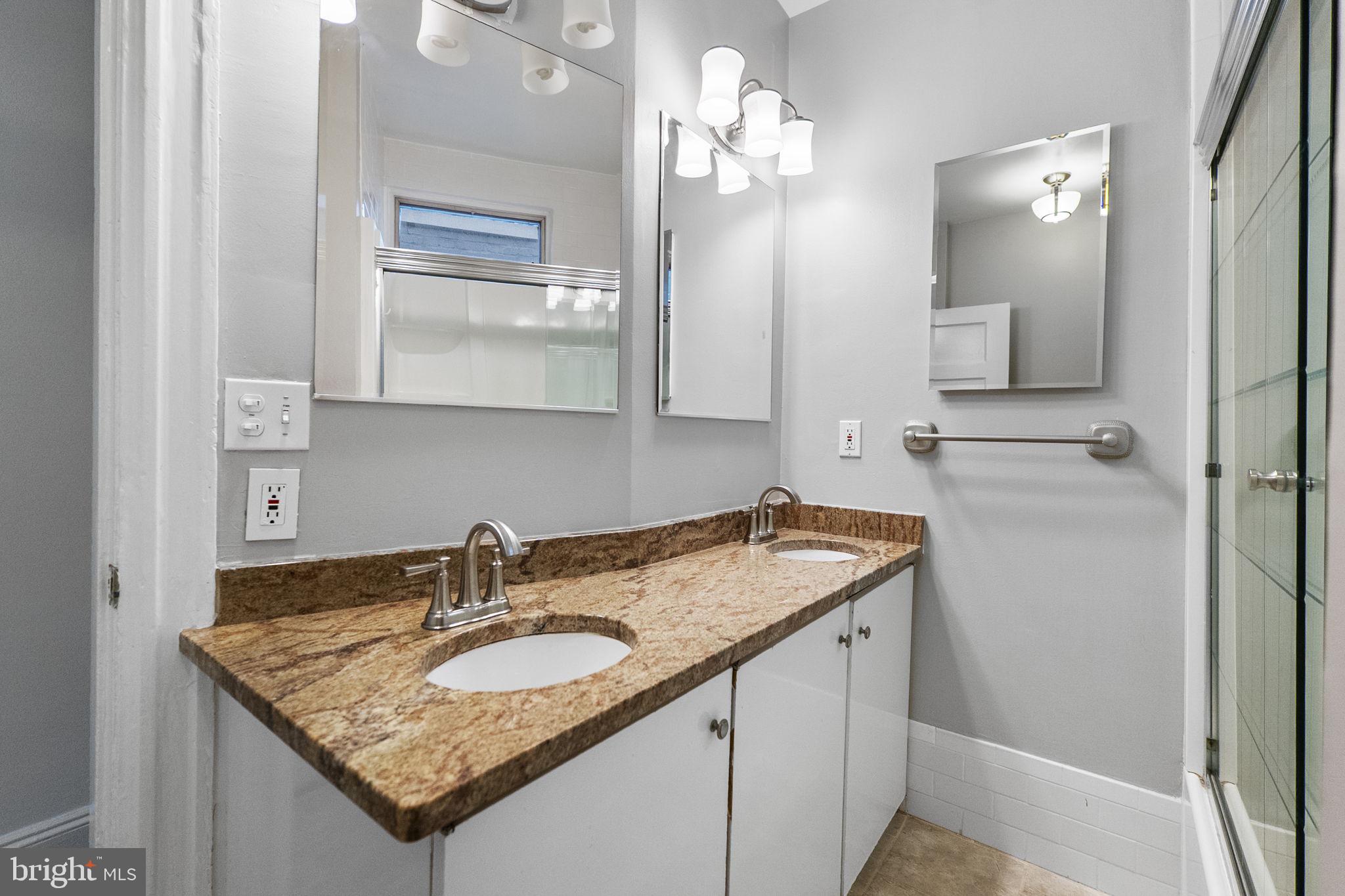 145 D Street Southeast Washington, DC 20003 - Photo 27 of 44 a bathroom with a granite countertop sink a mirror and shower
