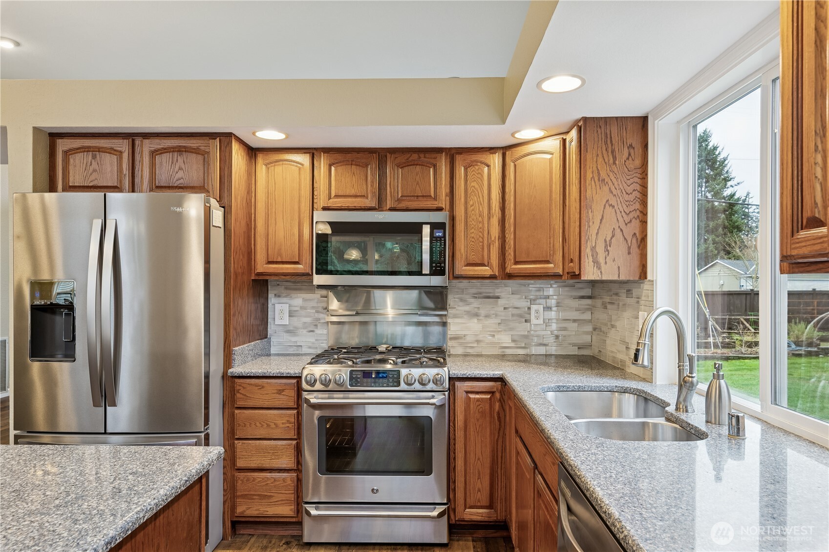2830 196th Street Southeast Bothell, WA 98012 - Photo 8 of 18 a kitchen with granite countertop a sink stove and refrigerator