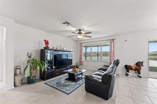 a living room with furniture a flat screen tv and a floor to ceiling window