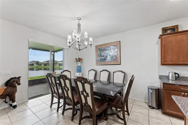 a view of a dining room with furniture a chandelier and window