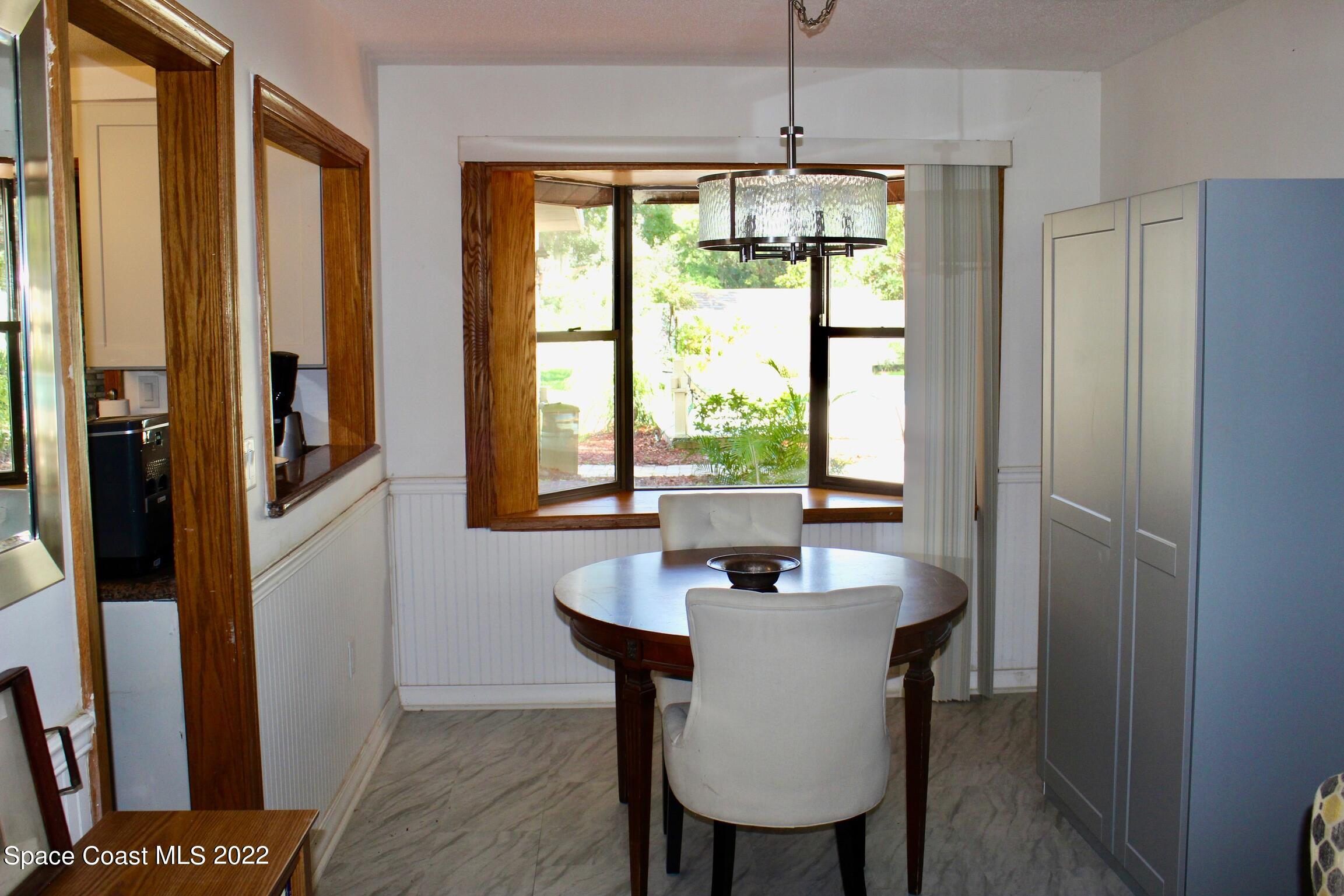 3665 Burkholm Road Mims, FL 32754 - Photo 22 of 62 a dining room with furniture a chandelier and wooden floor