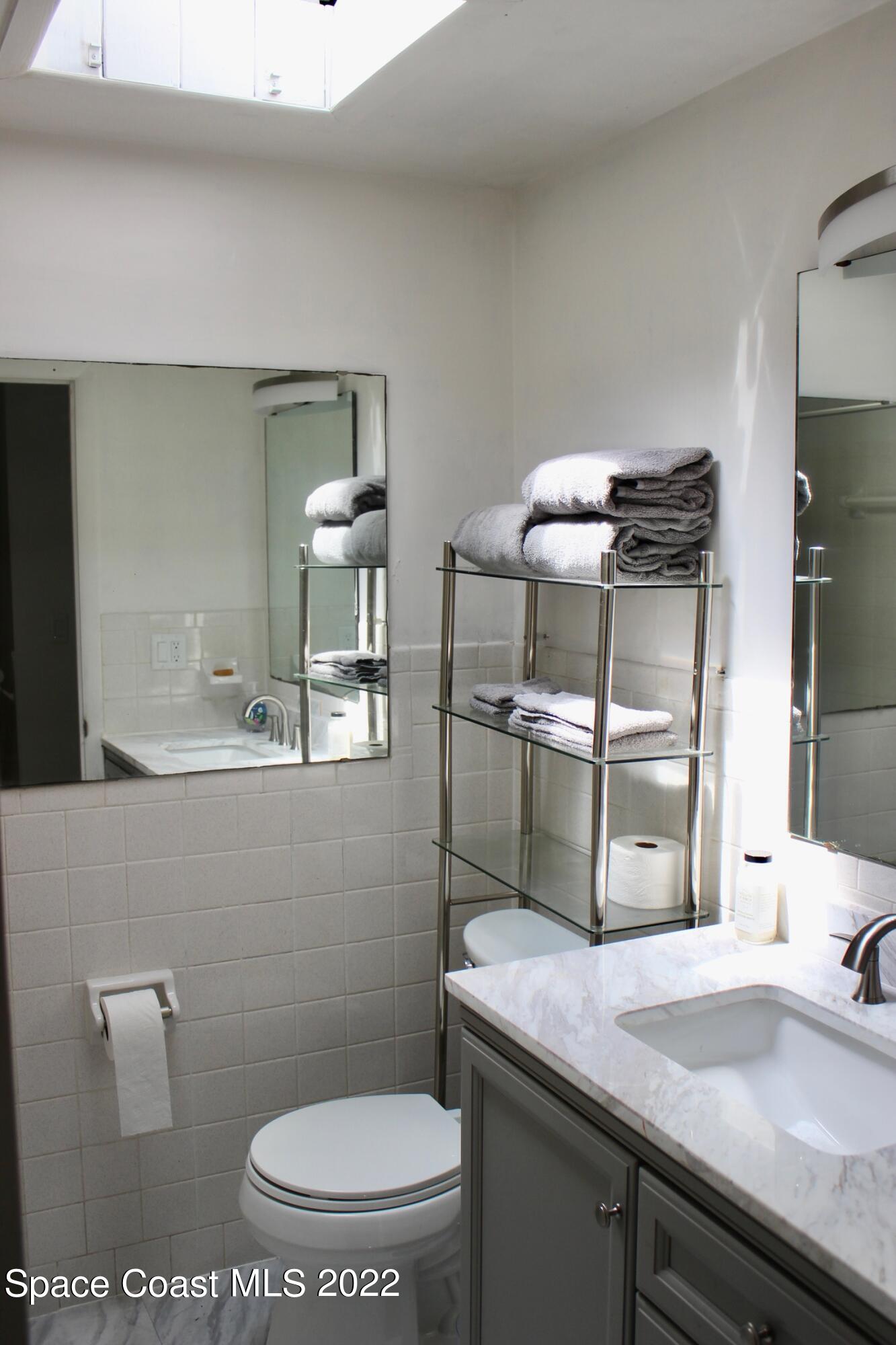 3665 Burkholm Road Mims, FL 32754 - Photo 34 of 62 a bathroom with a granite countertop toilet sink and mirror