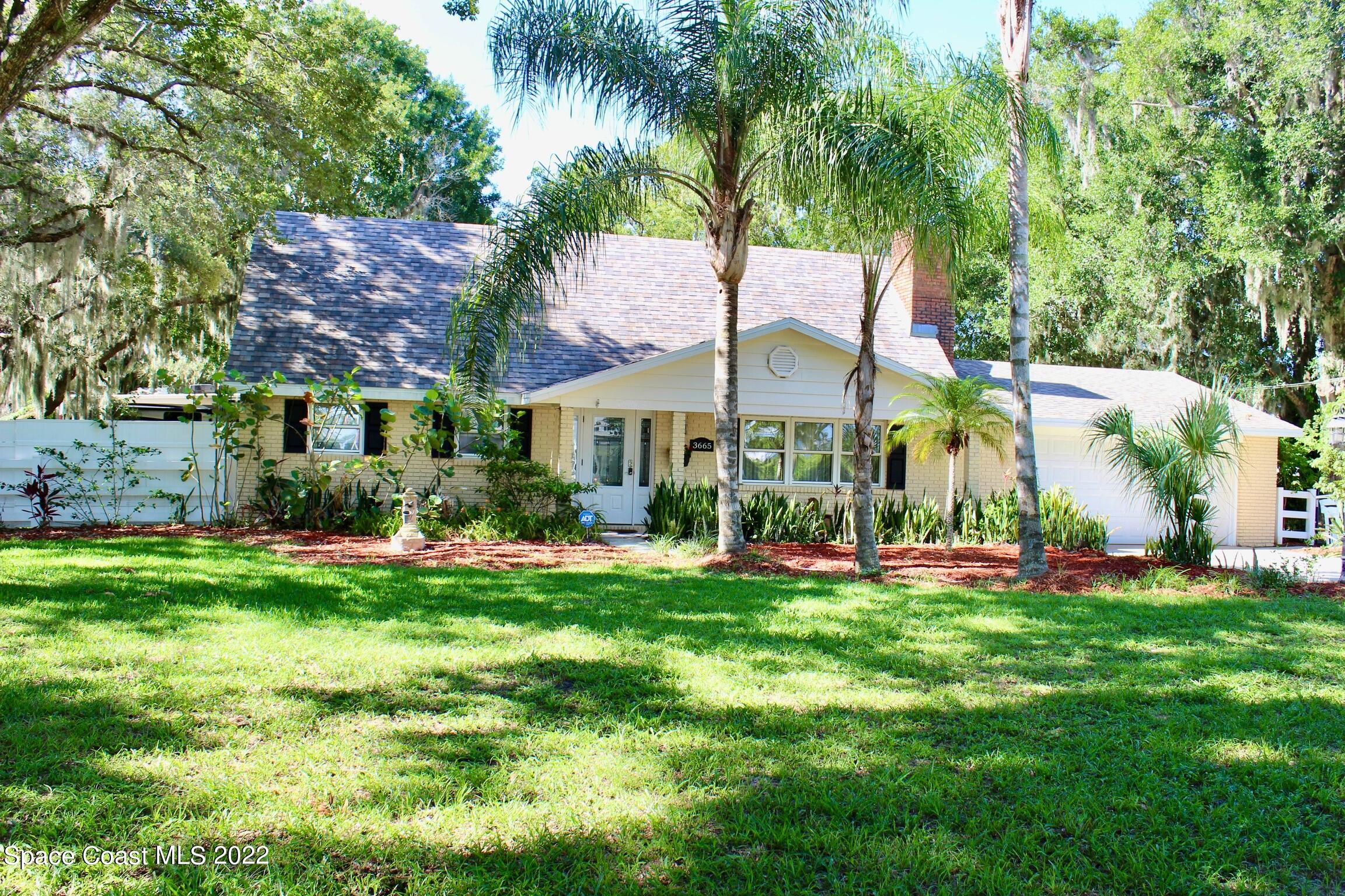 3665 Burkholm Road Mims, FL 32754 - Photo 4 of 62 a front view of a house with a garden and plants