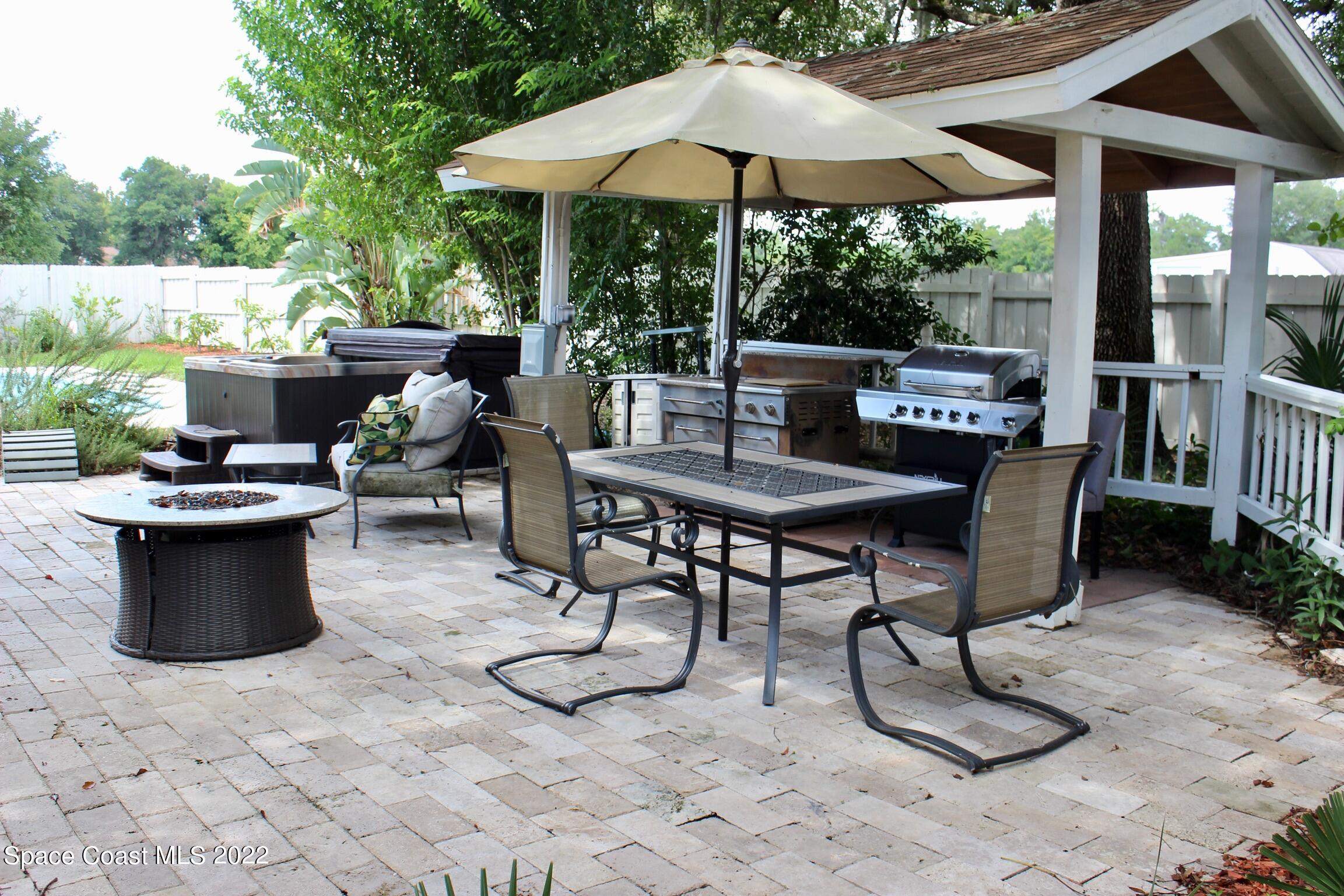 3665 Burkholm Road Mims, FL 32754 - Photo 43 of 62 a view of a patio with table and chairs under an umbrella