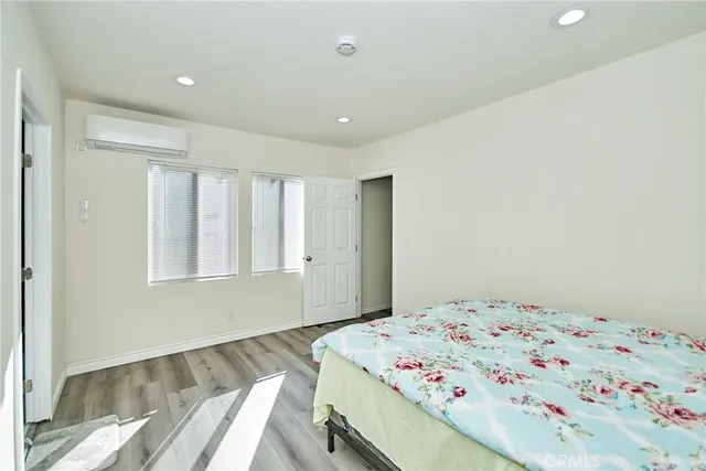 a bedroom with a bed and wooden floor