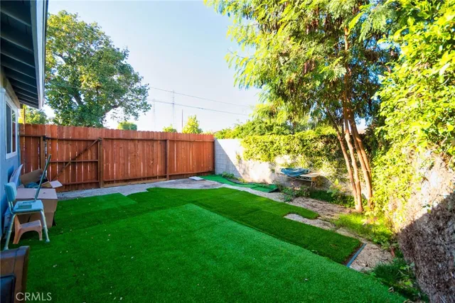 a view of backyard with table and chairs and wooden fence