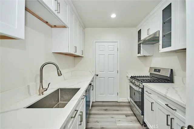 a kitchen with stainless steel appliances granite countertop a sink and a stove
