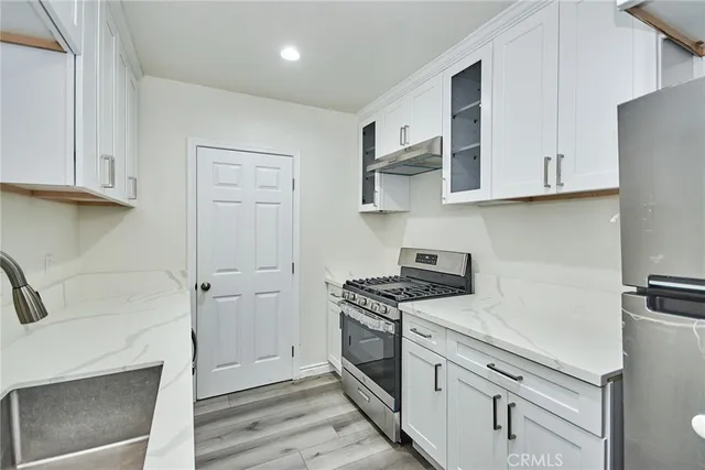 a kitchen with white cabinets and white appliances