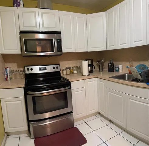 a kitchen with stainless steel appliances granite countertop a stove microwave and cabinets