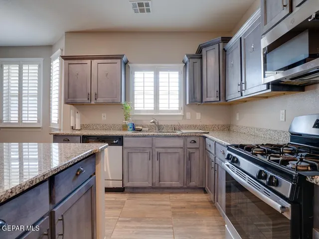 a kitchen with stainless steel appliances granite countertop a sink stove and cabinets