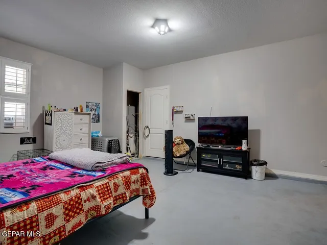 a bedroom with a bed furniture and a flat screen tv