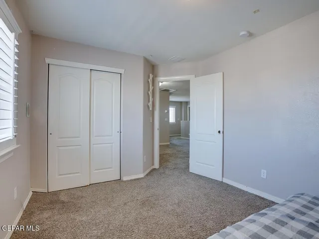 an empty room with closet and a window