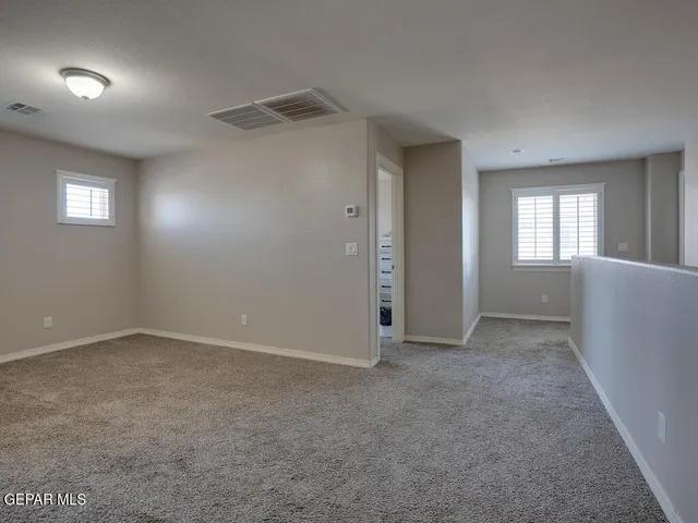 an empty room with windows and closet