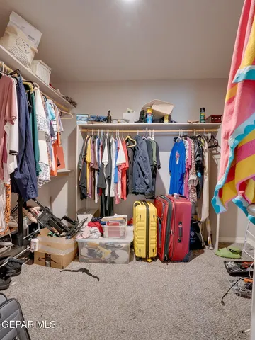 a view of walk in closet with clothes