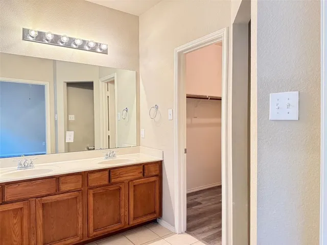 a bathroom with a double vanity sink and a mirror