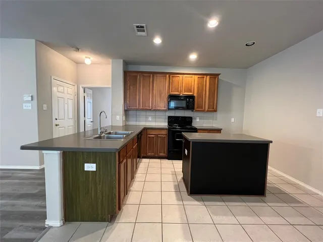 a kitchen with a sink a counter top space cabinets and appliances