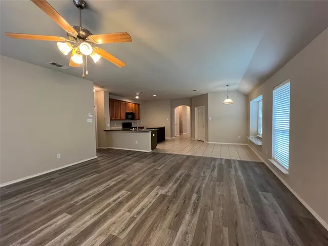 a view of a livingroom with a ceiling fan and wooden floor