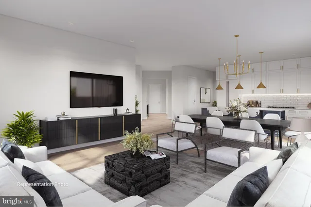 a living room with furniture a flat screen tv and kitchen view