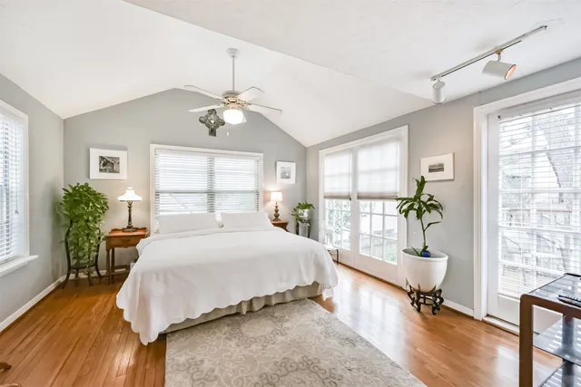 a bedroom with a large bed and a chandelier fan