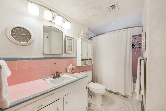 a bathroom with a granite countertop sink a toilet and a mirror