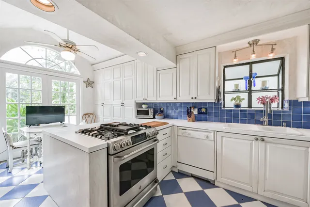 a kitchen with a stove a sink and a window
