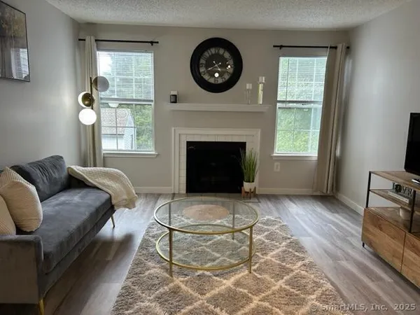 a living room with furniture a window and a fireplace