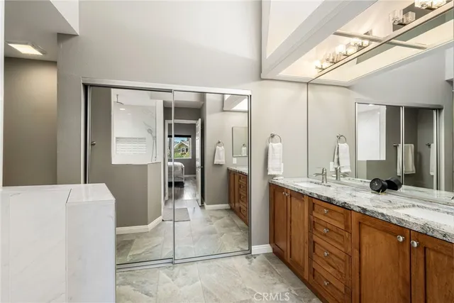 a bathroom with a granite countertop sink and a mirror