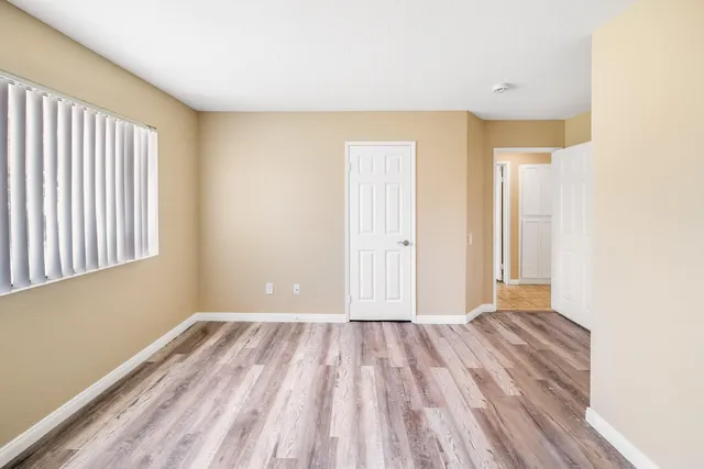 a view of a room with wooden floor and a window