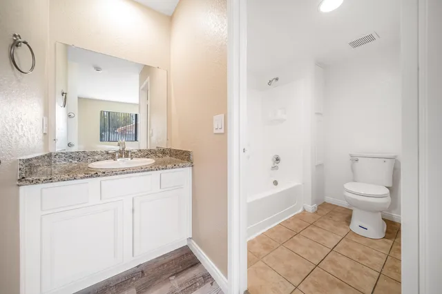 a bathroom with a granite countertop sink toilet and shower