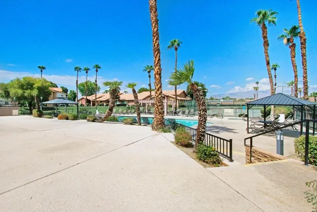 a view of a patio with a table and chairs under an umbrella