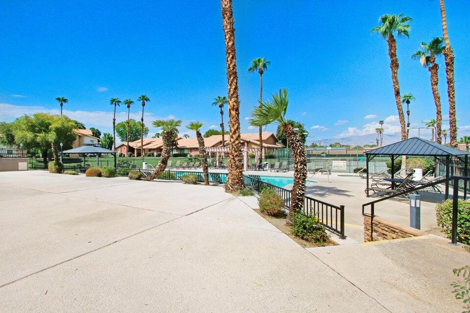 78650 Ave 42, Unit 1407 Bermuda Dunes, CA 92203 - Photo 19 of 20 a view of a patio with a table and chairs under an umbrella