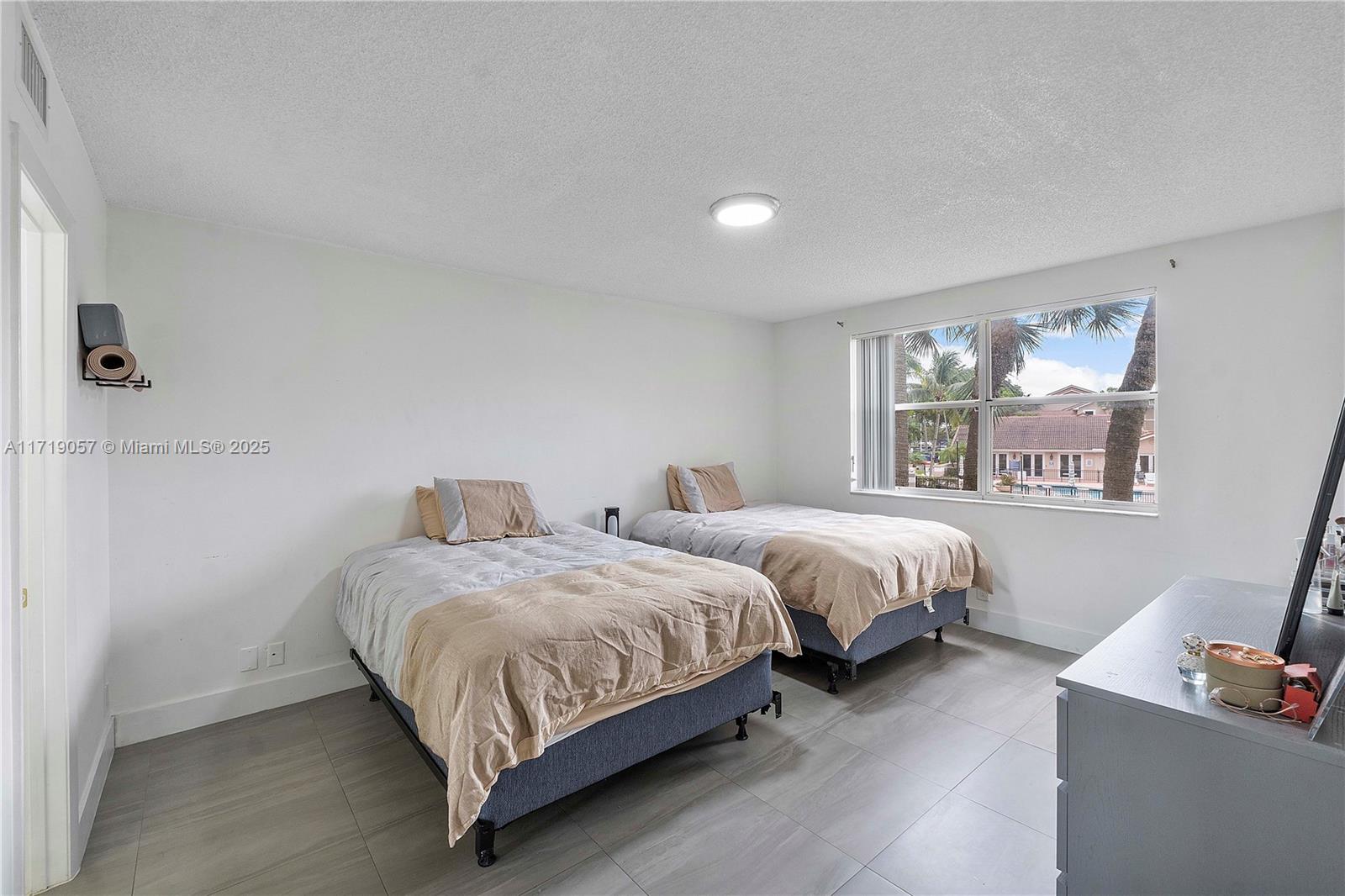 8871 Wiles Road, Unit 204 Coral Springs, FL 33067 - Photo 12 of 25 a bedroom with two beds and a window