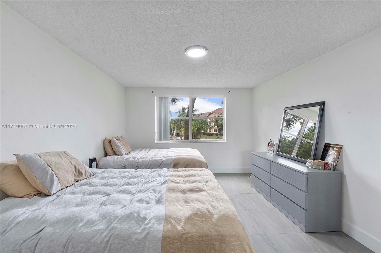 8871 Wiles Road, Unit 204 Coral Springs, FL 33067 - Photo 13 of 25 a bedroom with a large bed and a window