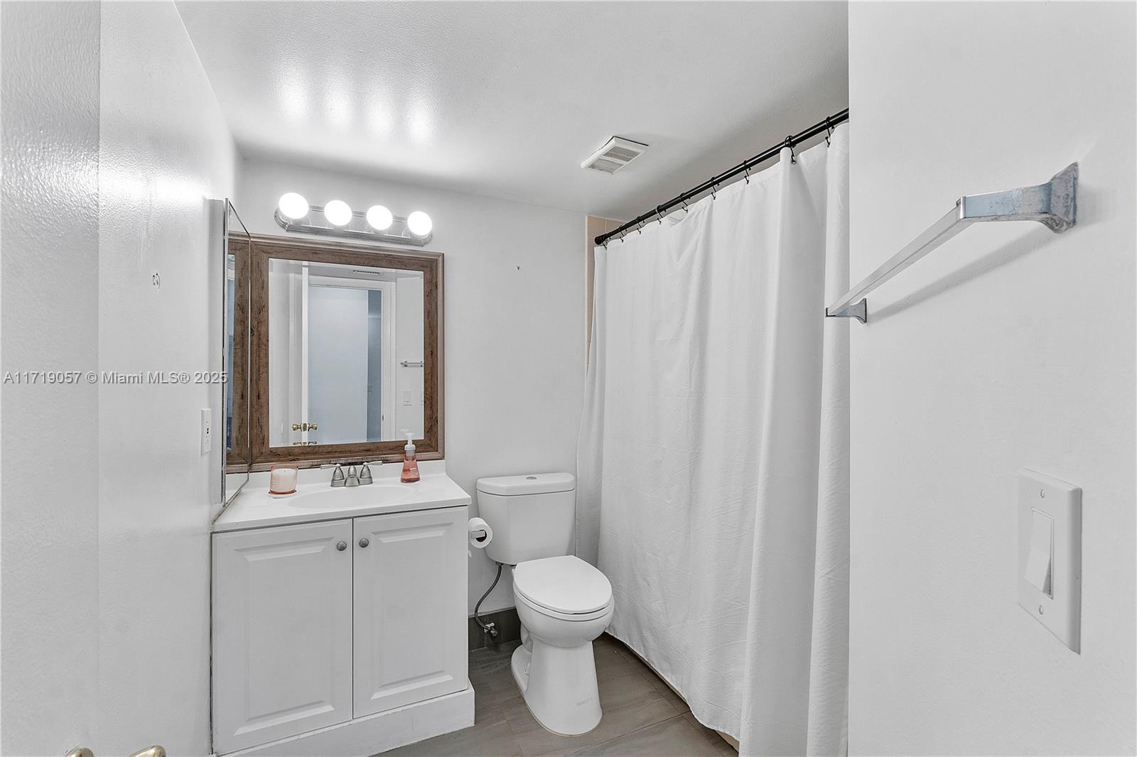 8871 Wiles Road, Unit 204 Coral Springs, FL 33067 - Photo 16 of 25 a bathroom with a toilet a sink and a mirror