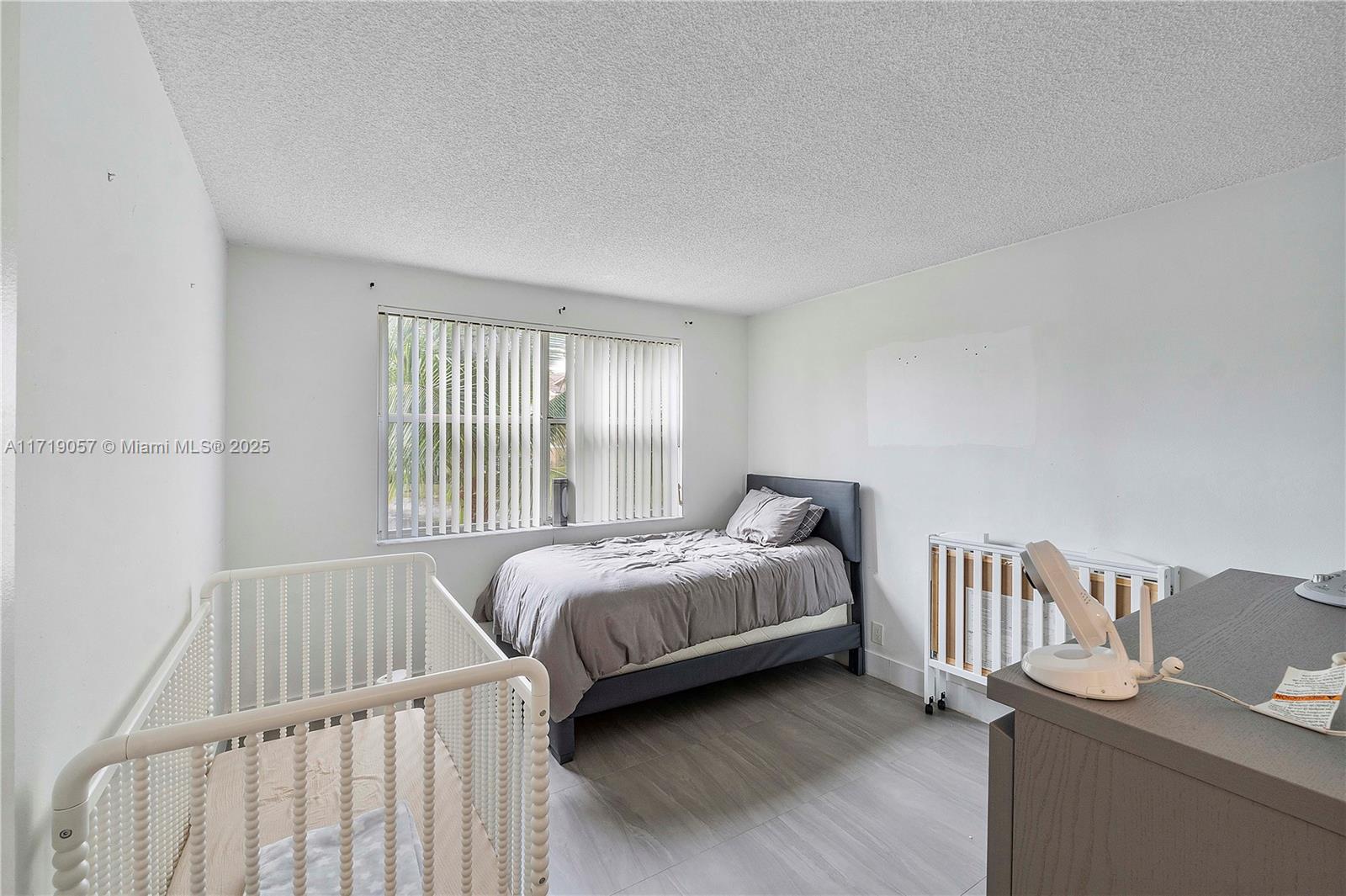 8871 Wiles Road, Unit 204 Coral Springs, FL 33067 - Photo 18 of 25 a bedroom with a bed and a window
