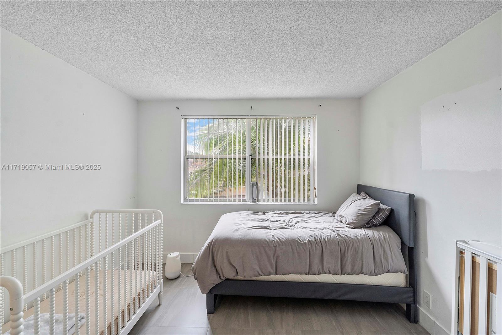 8871 Wiles Road, Unit 204 Coral Springs, FL 33067 - Photo 19 of 25 a bedroom with a bed and a window