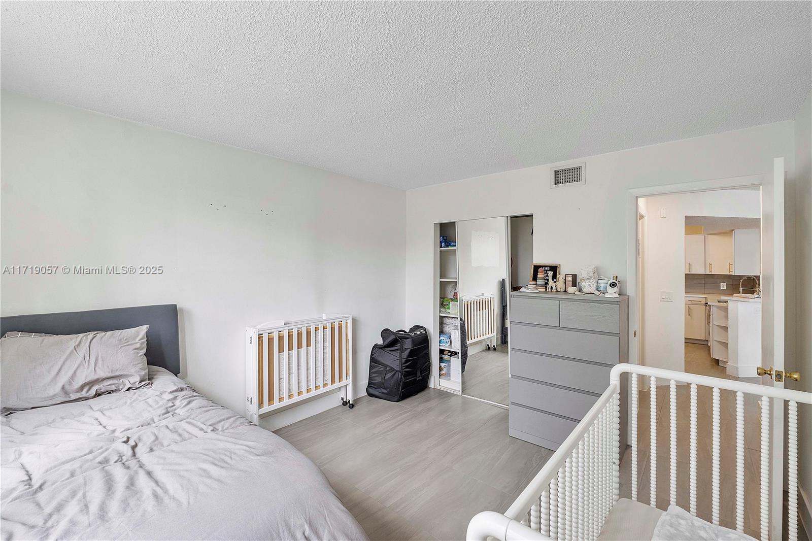 8871 Wiles Road, Unit 204 Coral Springs, FL 33067 - Photo 20 of 25 a bedroom with a bed and a view of bedroom
