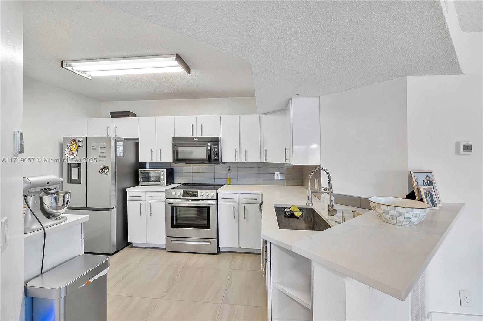 8871 Wiles Road, Unit 204 Coral Springs, FL 33067 - Photo 2 of 25 a kitchen with a sink a stove and refrigerator