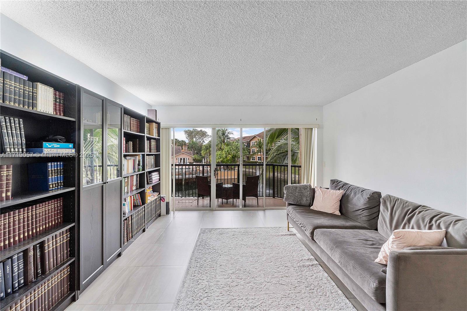 8871 Wiles Road, Unit 204 Coral Springs, FL 33067 - Photo 8 of 25 a living room with furniture a rug and a book shelf