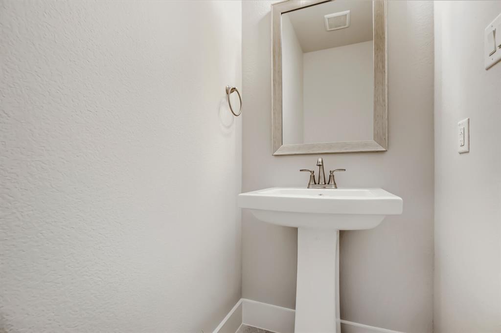 4407 Windy Point Road Oak Point, TX 75068 - Photo 19 of 27 Pedestal sink with brushed nickel faucet, framed mirror, and a wall-mounted towel ring