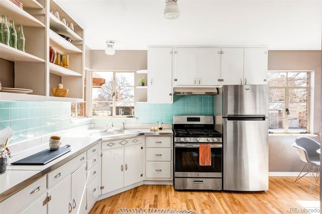 a kitchen with stainless steel appliances granite countertop a refrigerator a stove and a sink