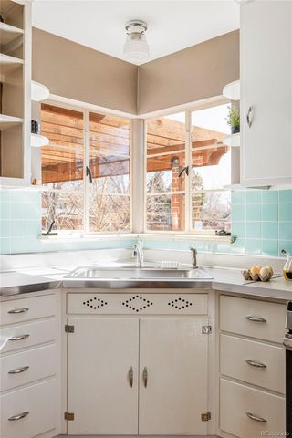 a kitchen with granite countertop white cabinets and a window