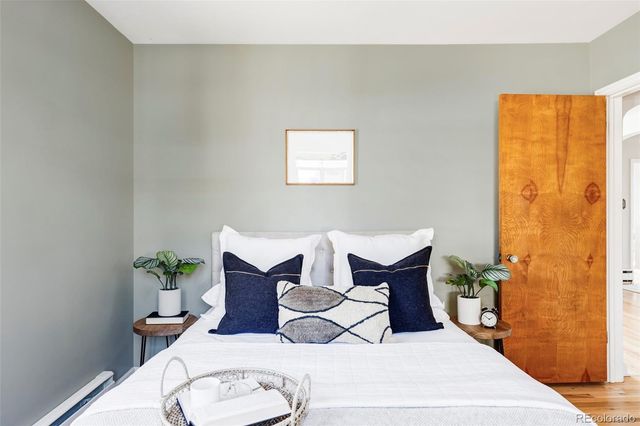 a bedroom with a bed and wooden floor