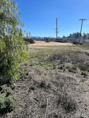 a view of a dry yard with wooden fence