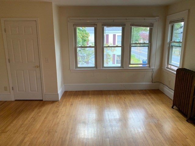 237 Bridge Street Northampton, MA 01060 - Photo 13 of 14 an empty room with wooden floor and windows with curtains