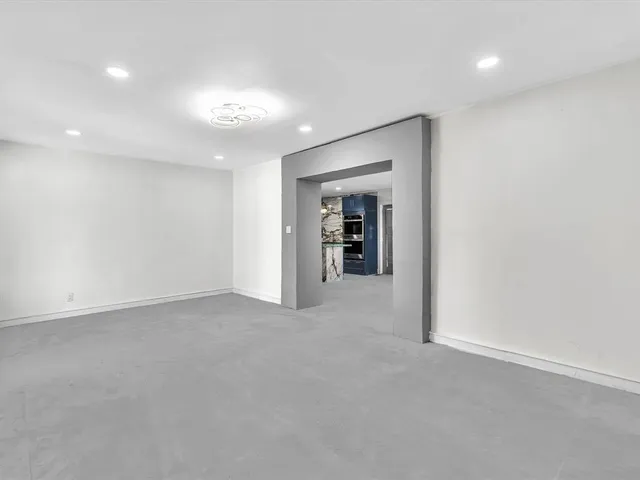 a kitchen with stainless steel appliances kitchen island granite countertop a refrigerator and a stove top oven